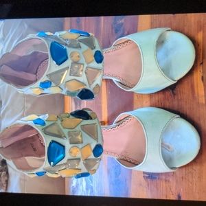 Pale blue high heels embellished ankle straps with fake jewels.